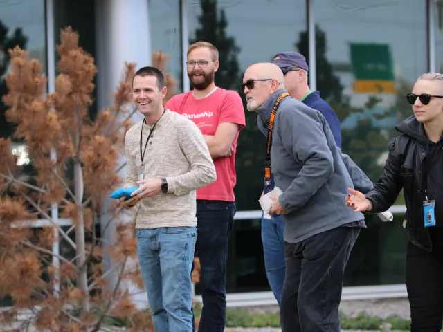 employees playing corn hole outside
